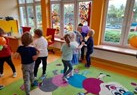 grupa tańczy na kolorowym dywanie